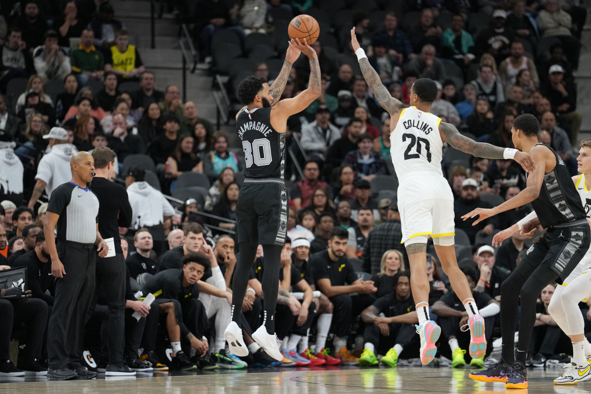 Dec 26, 2023; San Antonio, Texas, USA; San Antonio Spurs forward Julian Champagnie (30) shoots over Utah Jazz forward John Collins (20) in the first half at the Frost Bank Center.